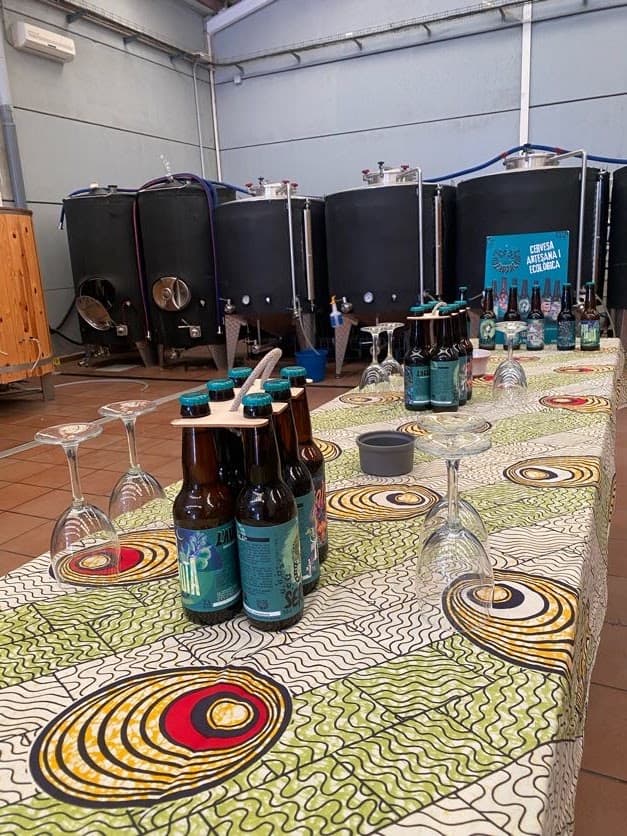 Cervecería L'audaç - La Somniada Coop.V Cervezas artesanas en cata con equipo de fermentación en fondo industrial.